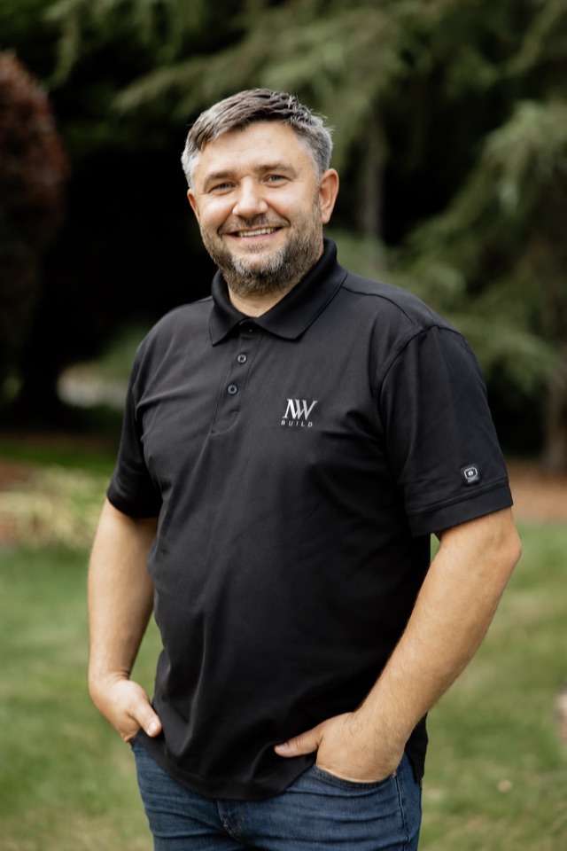 Ivan Turchik standing outdoors in an NW Build polo shirt.