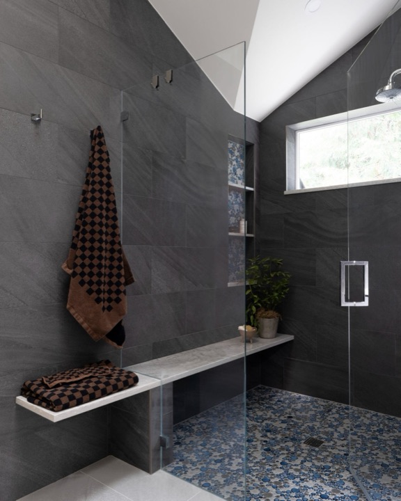 Bathroom by NW Build with large-format dark tile, a glass shower screen and a floating stone shelf.